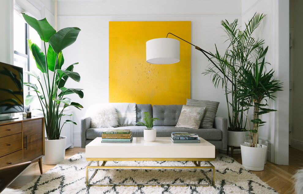 Foto di un soggiorno contemporaneo con pareti bianche, parquet chiaro, TV autoportante e pavimento marrone