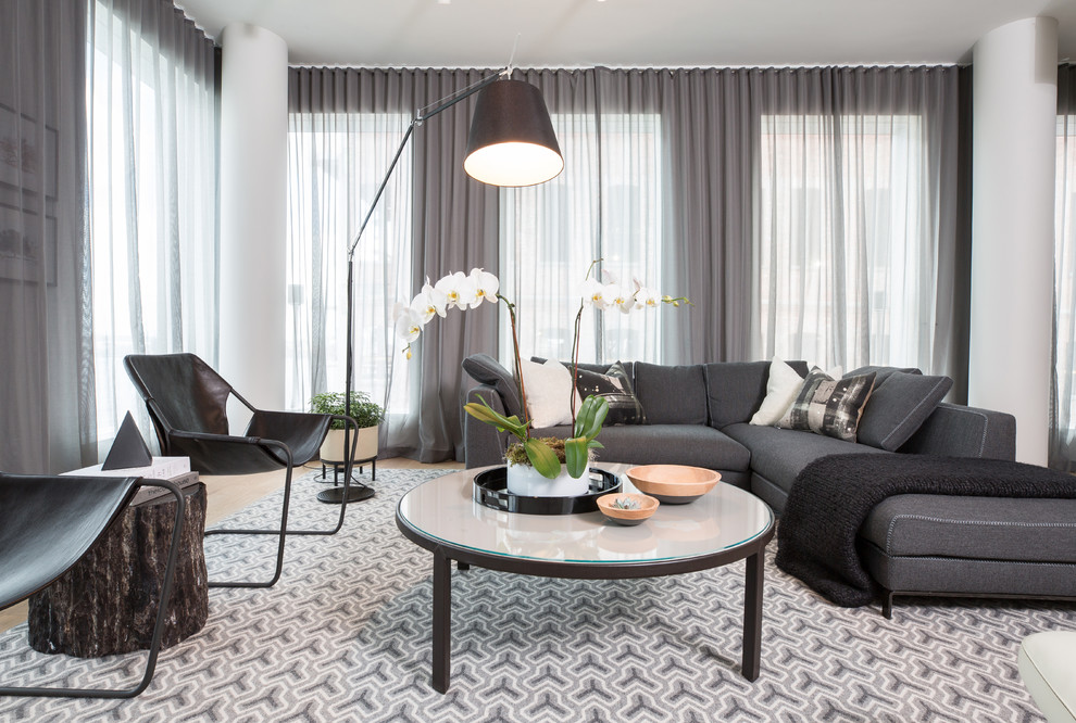 Ispirazione per un soggiorno design chiuso con pareti grigie, parquet chiaro e pavimento beige