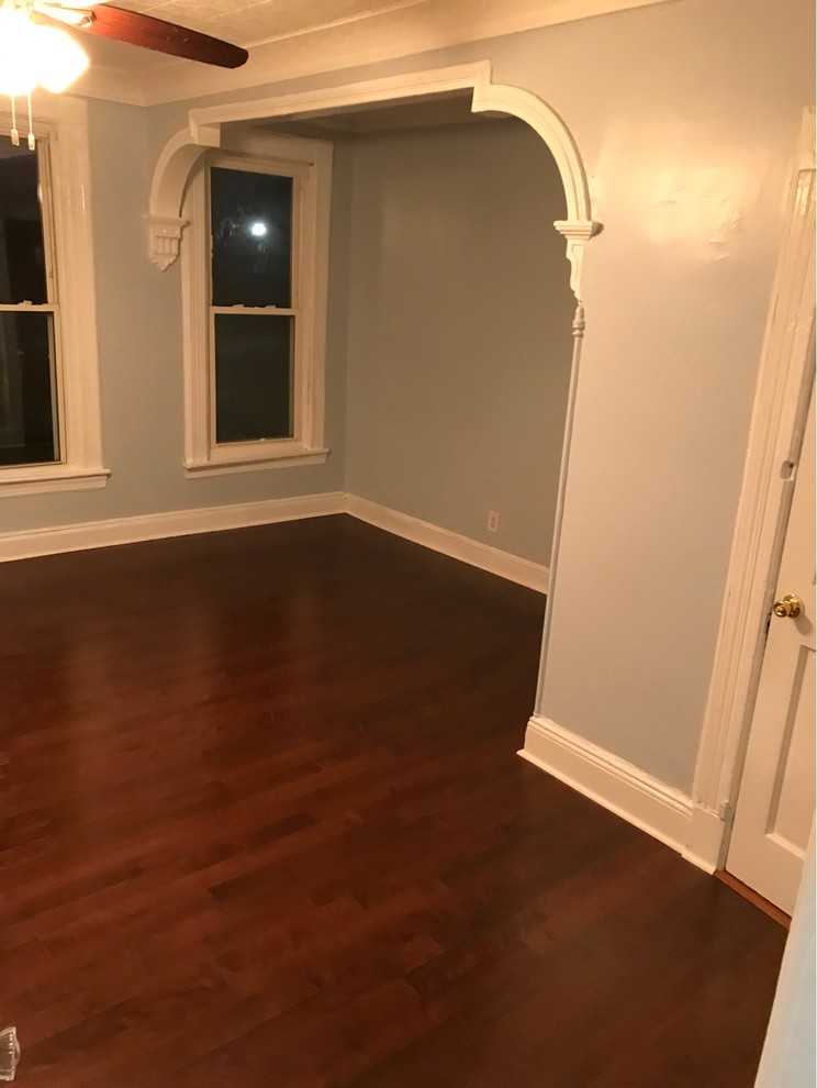 Mittelgroßes Klassisches Wohnzimmer ohne Kamin mit blauer Wandfarbe, dunklem Holzboden und braunem Boden in New York