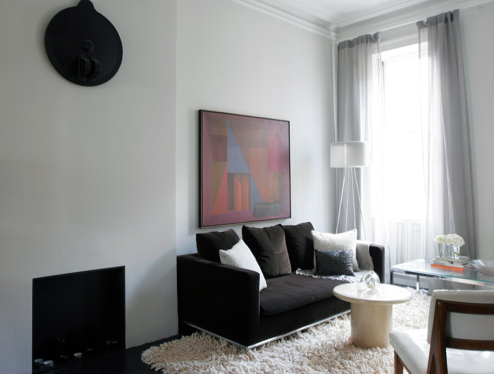Immagine di un piccolo soggiorno moderno aperto con sala formale, pareti grigie, pavimento in legno verniciato, camino classico, cornice del camino in legno e nessuna TV
