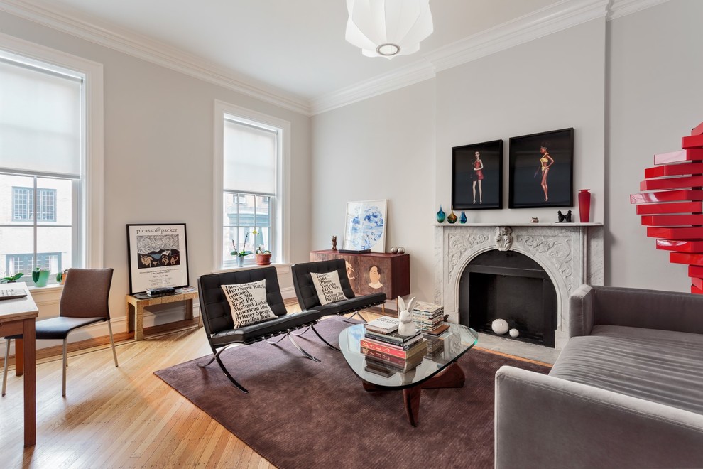 Источник вдохновения для домашнего уюта: гостиная комната в современном стиле с серыми стенами, паркетным полом среднего тона и стандартным камином без телевизора