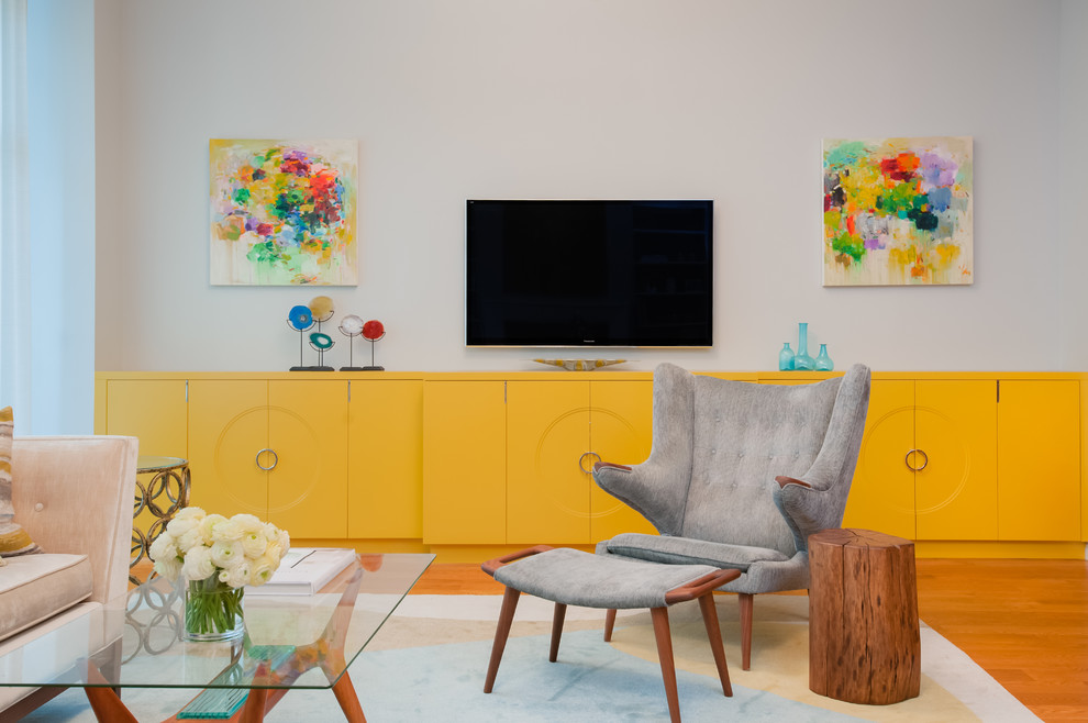 Immagine di un grande soggiorno tradizionale con pareti grigie, pavimento in legno massello medio e TV a parete