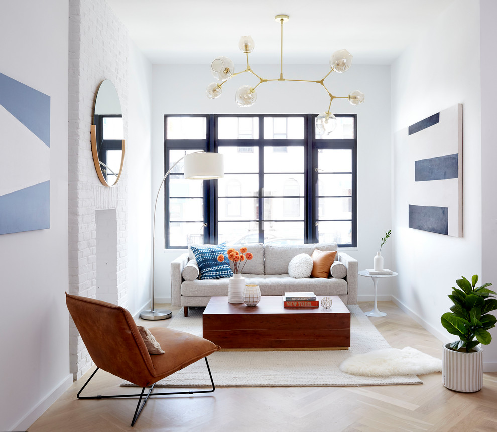 Inspiration för moderna vardagsrum, med ett finrum, vita väggar, ljust trägolv, en standard öppen spis, en spiselkrans i tegelsten och brunt golv