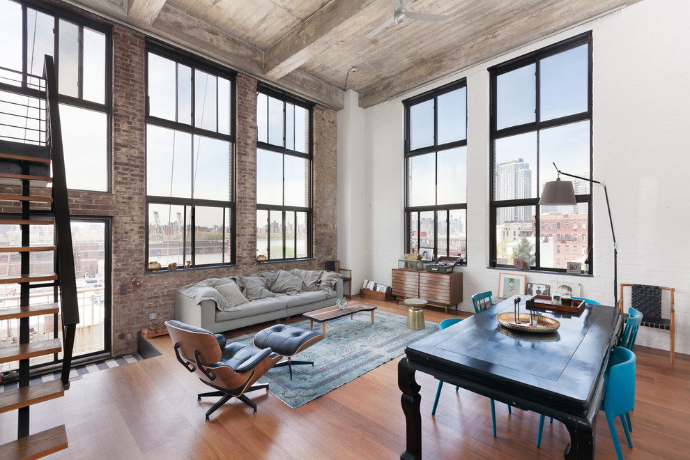 Offenes Industrial Wohnzimmer mit bunten Wänden und braunem Holzboden in New York