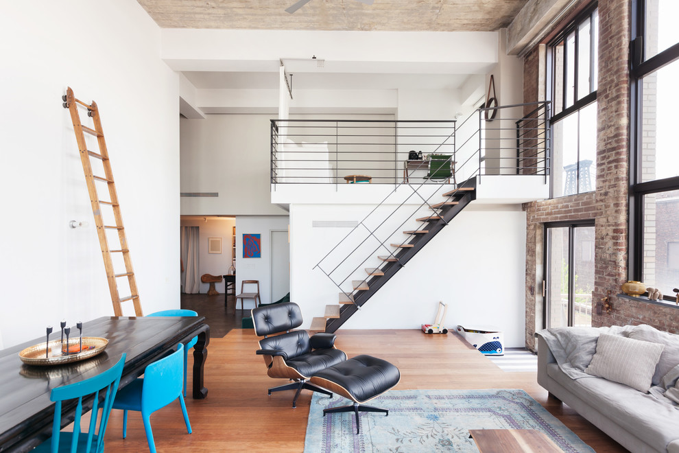 Offenes Industrial Wohnzimmer mit bunten Wänden und braunem Holzboden in New York