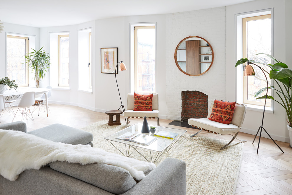 Cette image montre un salon design avec un sol en bois brun, une cheminée standard, un manteau de cheminée en brique et un sol blanc.