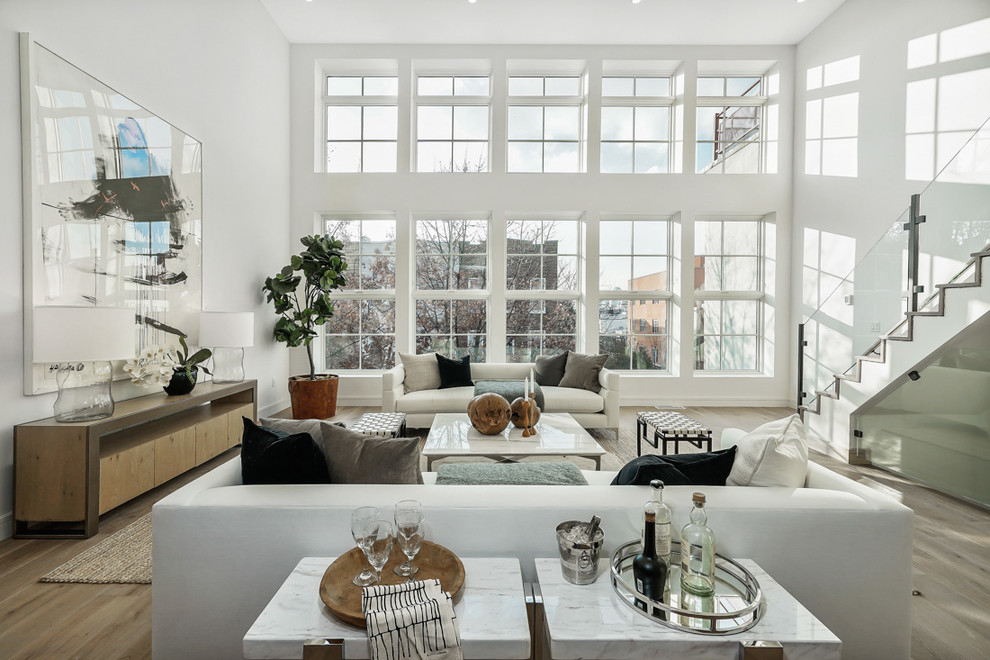 Idee per un soggiorno design con pareti bianche, parquet chiaro e pavimento beige