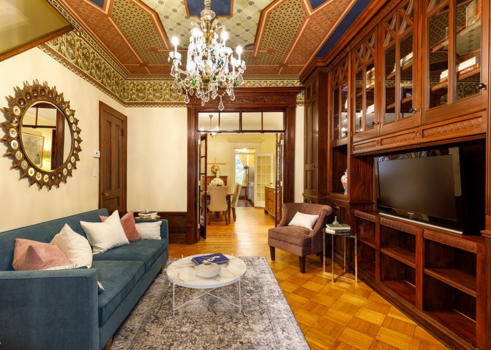 Idée de décoration pour un salon design de taille moyenne et fermé avec une salle de réception, un mur beige, un sol en bois brun, une cheminée standard et un manteau de cheminée en pierre.