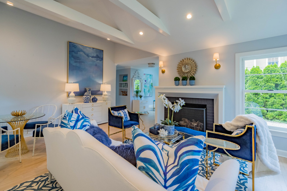 Aménagement d'un grand salon bord de mer ouvert avec une salle de réception, un mur bleu, une cheminée standard, un manteau de cheminée en carrelage, aucun téléviseur et un sol beige.