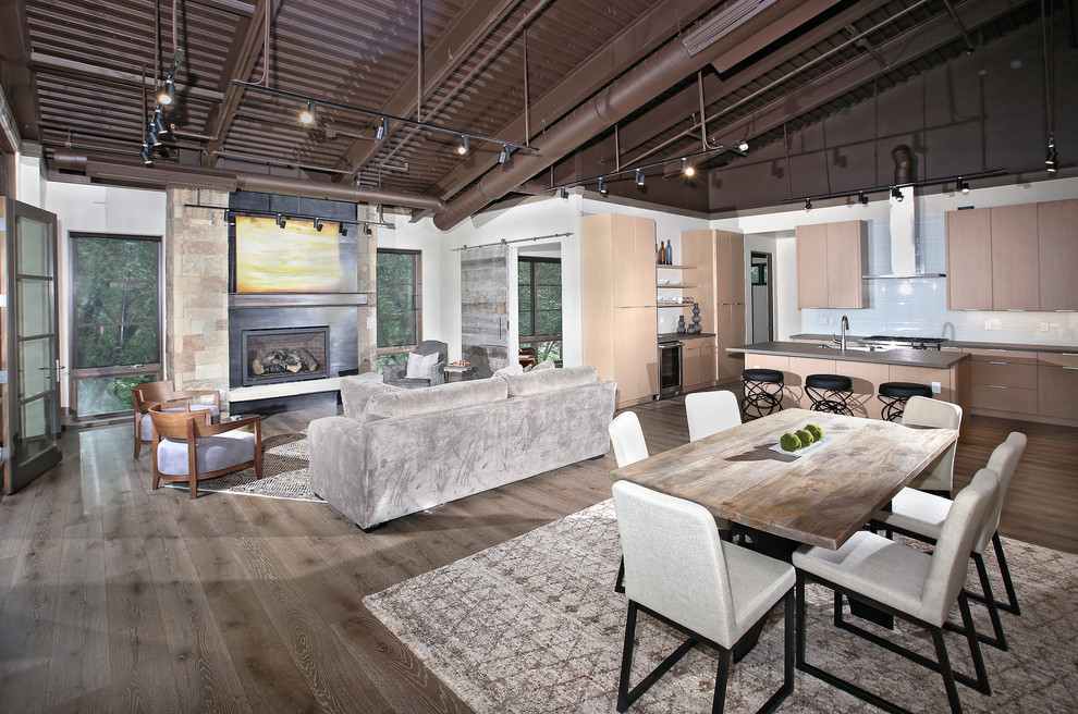 Inspiration for a mid-sized industrial open concept medium tone wood floor living room remodel in Denver with gray walls, a standard fireplace and a stone fireplace