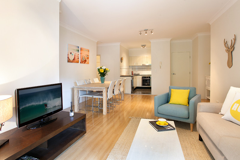 Kleines, Offenes Maritimes Wohnzimmer ohne Kamin mit weißer Wandfarbe, hellem Holzboden und freistehendem TV in Sydney