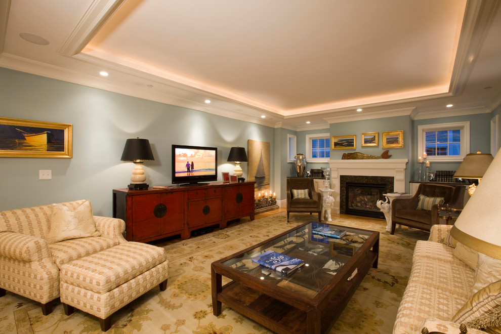 Inredning av ett klassiskt stort separat vardagsrum, med blå väggar, ljust trägolv, en standard öppen spis, en spiselkrans i gips och en fristående TV