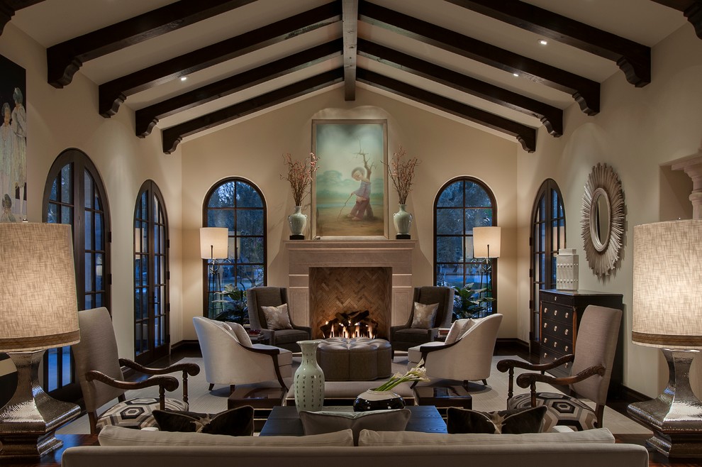 This is an example of a large mediterranean formal open plan living room in Phoenix with beige walls, dark hardwood flooring, a standard fireplace, a stone fireplace surround, no tv and brown floors.