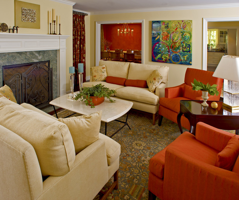 На фото: гостиная комната в классическом стиле с желтыми стенами и стандартным камином с
