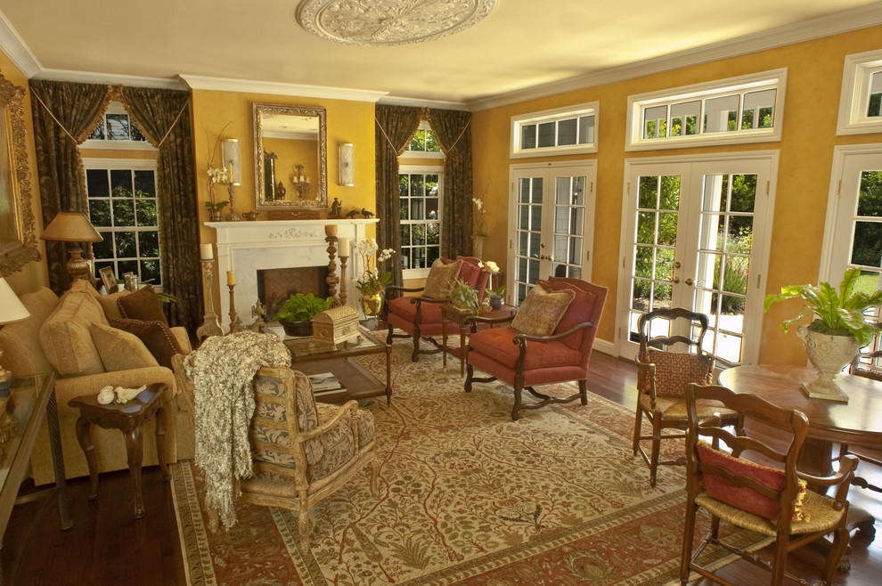 Идея дизайна: гостиная комната в классическом стиле с желтыми стенами и стандартным камином