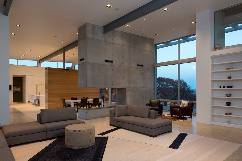 Imagen de salón abierto contemporáneo extra grande sin televisor con suelo de cemento, paredes blancas, chimenea de esquina y marco de chimenea de hormigón