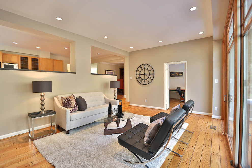 Medium sized contemporary formal open plan living room in Toronto with beige walls, medium hardwood flooring, a standard fireplace, a tiled fireplace surround, no tv and brown floors.