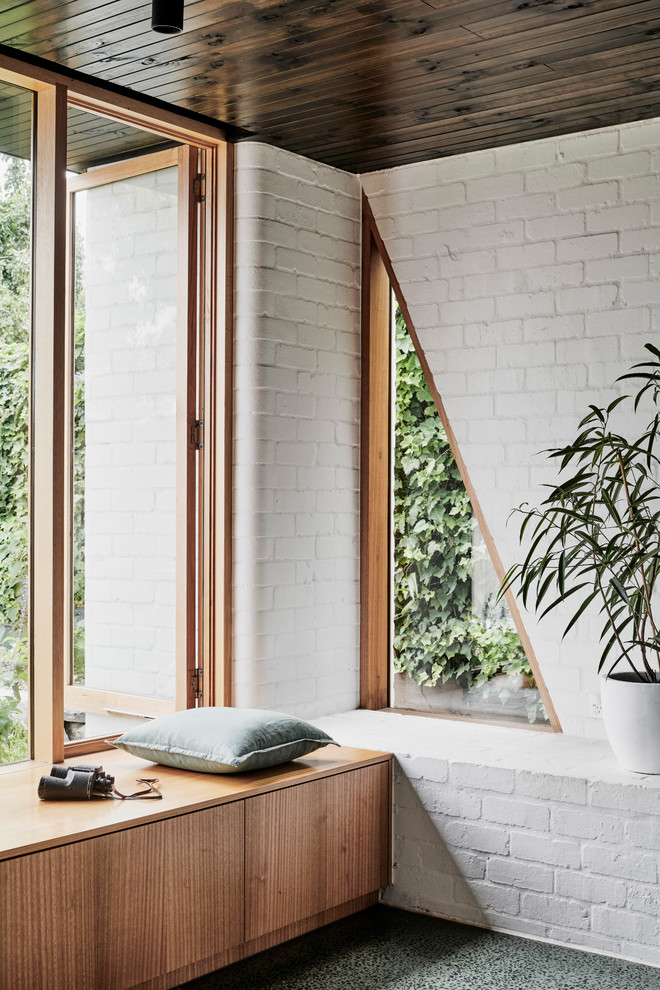 Cette photo montre un salon moderne de taille moyenne et ouvert avec un mur blanc, sol en béton ciré, un poêle à bois, un manteau de cheminée en métal et un sol vert.