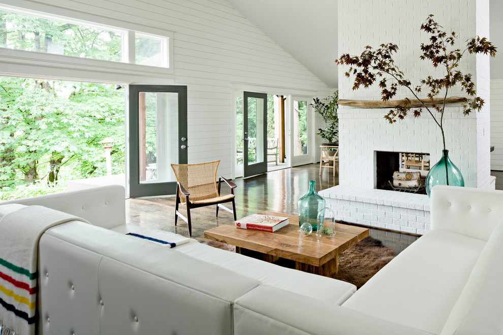 Aménagement d'un salon contemporain ouvert avec un mur blanc, une cheminée double-face, un manteau de cheminée en brique et aucun téléviseur.