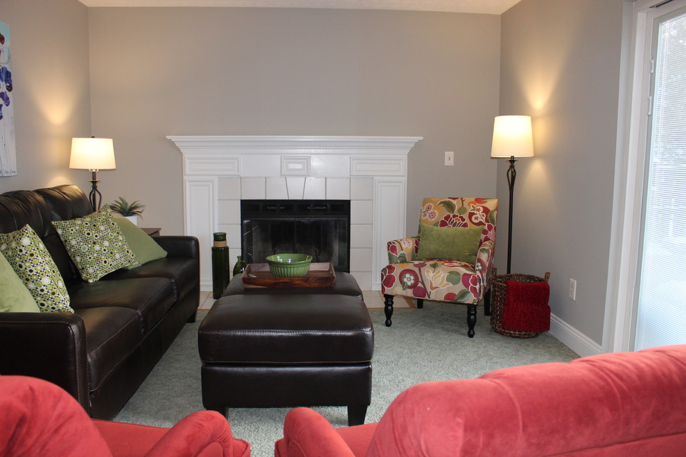 На фото: открытая гостиная комната среднего размера в стиле фьюжн с серыми стенами, ковровым покрытием, стандартным камином, фасадом камина из дерева, телевизором на стене и зеленым полом с