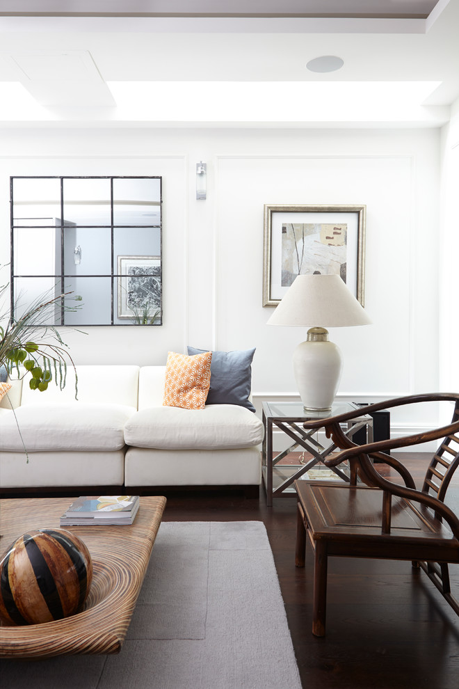 This is an example of a classic formal living room in London with white walls and dark hardwood flooring.