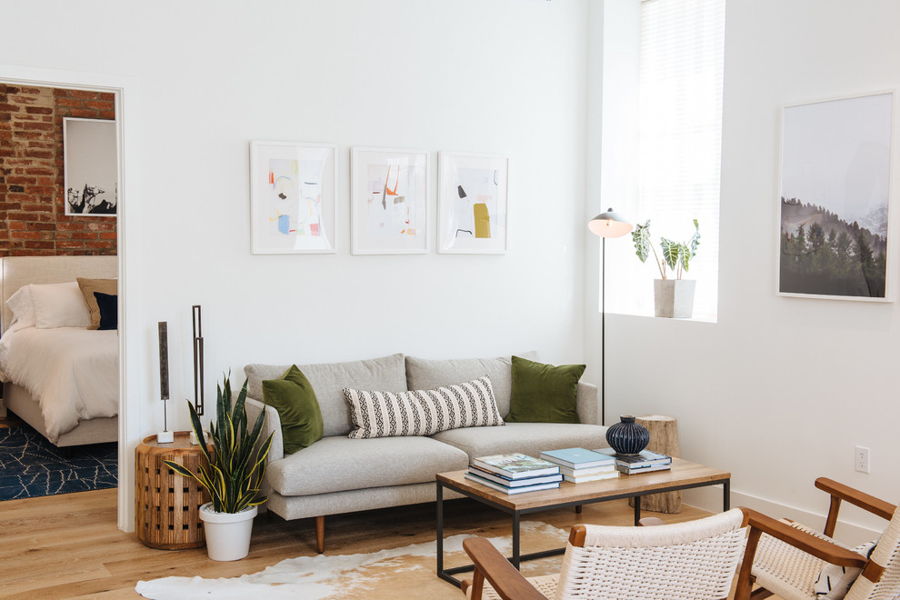 Idee per un soggiorno minimal con pareti bianche, pavimento in legno massello medio e pavimento marrone