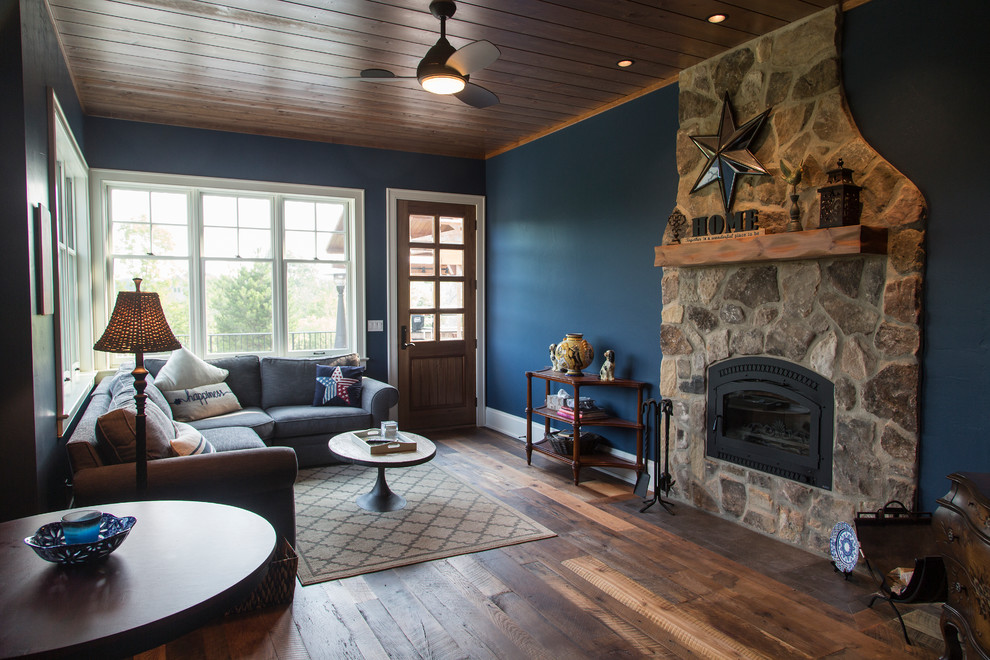 Идея дизайна: парадная гостиная комната среднего размера в стиле рустика с синими стенами, темным паркетным полом, стандартным камином и фасадом камина из камня без телевизора