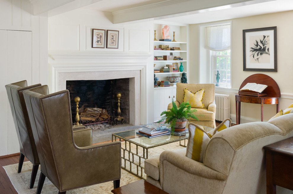 Inspiration for a mid-sized country enclosed medium tone wood floor living room library remodel in Philadelphia with beige walls, a standard fireplace, a stone fireplace and no tv