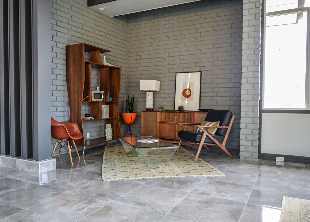 Imagen de salón abierto actual pequeño sin chimenea y televisor con paredes grises, suelo de cemento y suelo gris