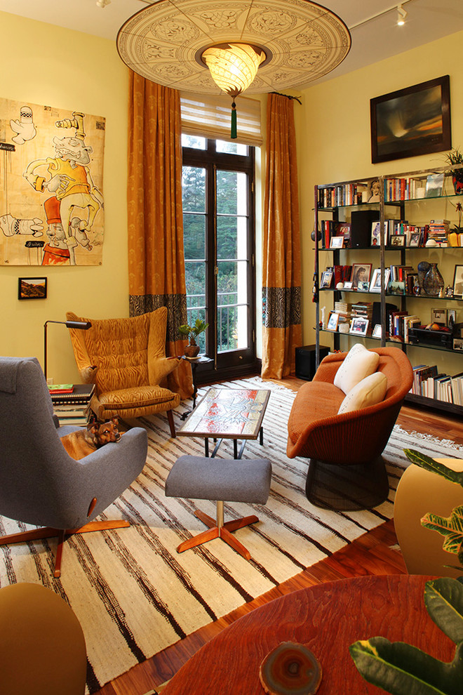 Idee per un piccolo soggiorno bohémian aperto con pareti gialle e pavimento in legno massello medio