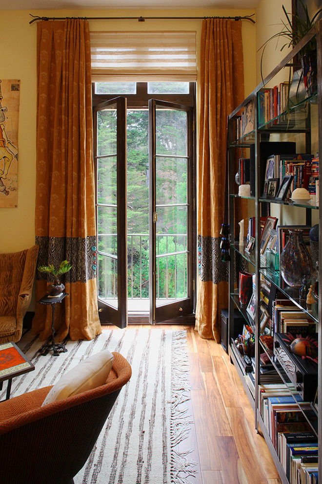 Ispirazione per un piccolo soggiorno boho chic aperto con sala formale, pareti gialle e pavimento in legno massello medio