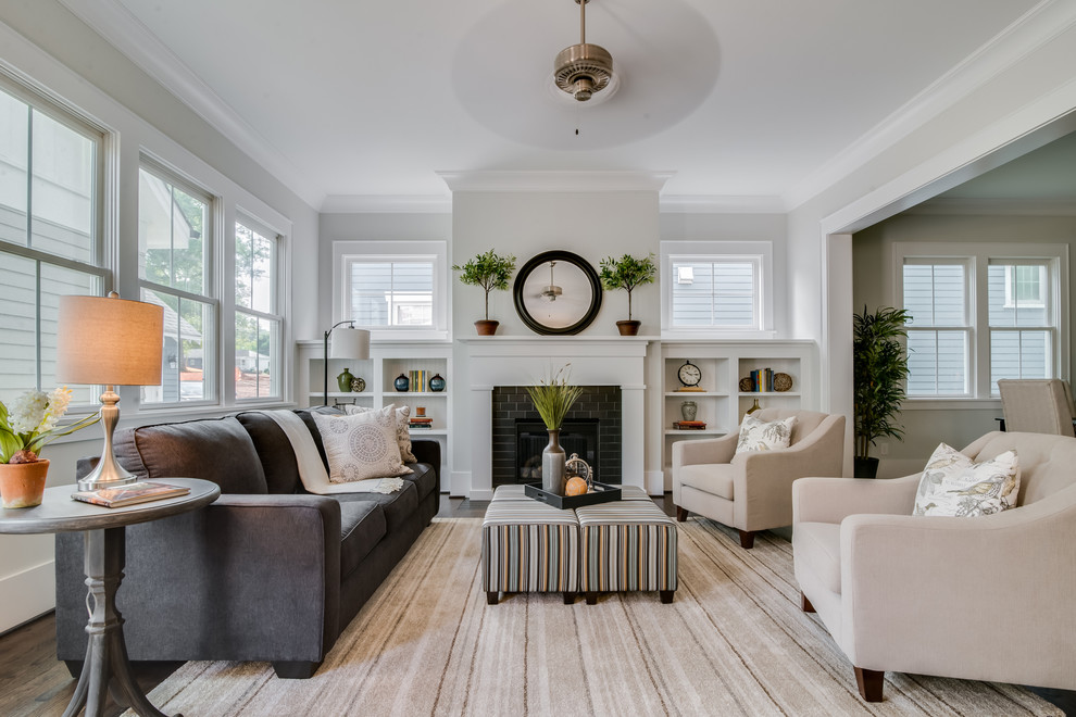 Example of a classic dark wood floor living room design in Charlotte with gray walls, a standard fireplace and a brick fireplace