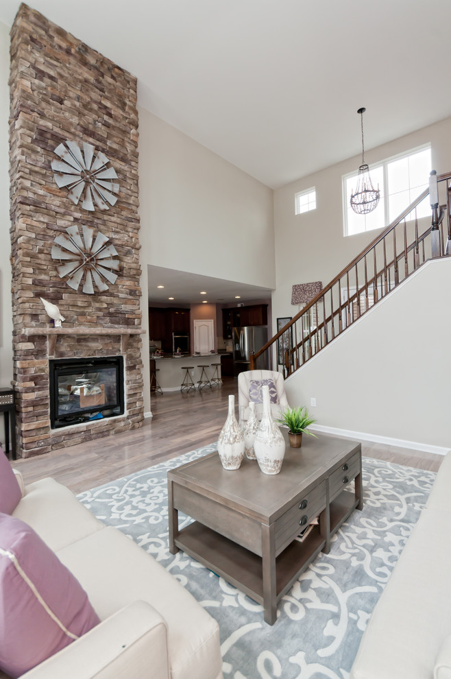 Стильный дизайн: гостиная комната в классическом стиле с фасадом камина из камня - последний тренд