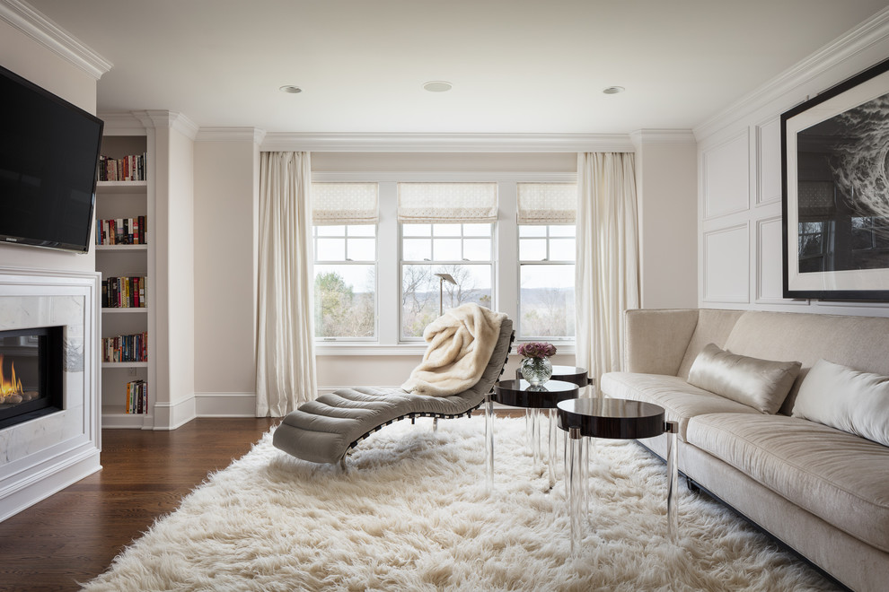 Idee per un soggiorno classico con pareti beige, pavimento in legno massello medio, camino classico, TV a parete e pavimento marrone