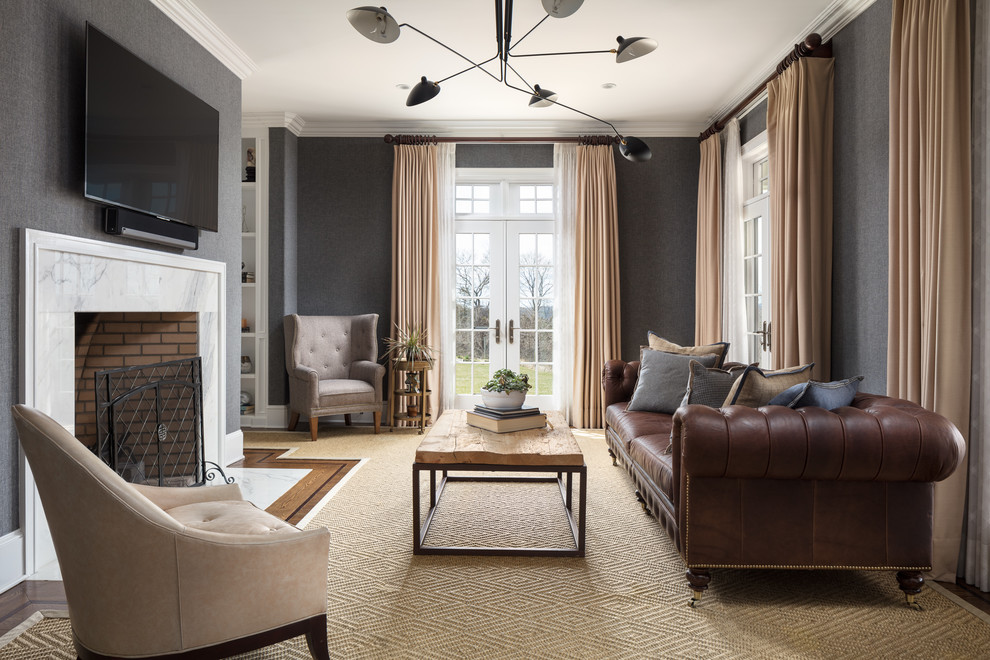 Example of a classic medium tone wood floor and brown floor living room design in New York with gray walls, a standard fireplace and a wall-mounted tv