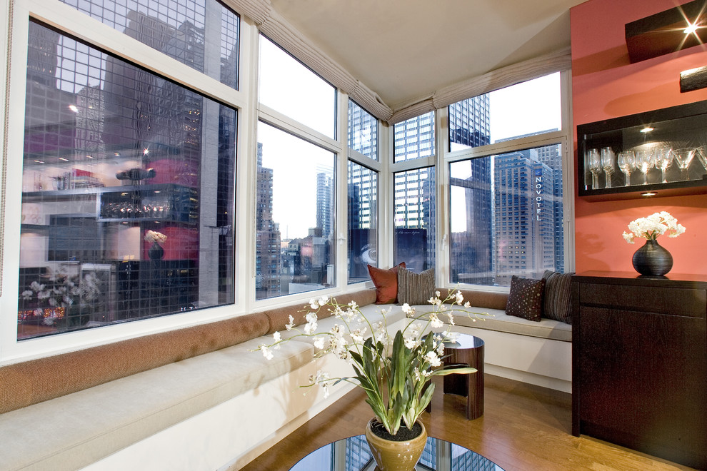 Immagine di un soggiorno minimal di medie dimensioni e aperto con angolo bar, parete attrezzata, pareti rosse e pavimento in legno massello medio