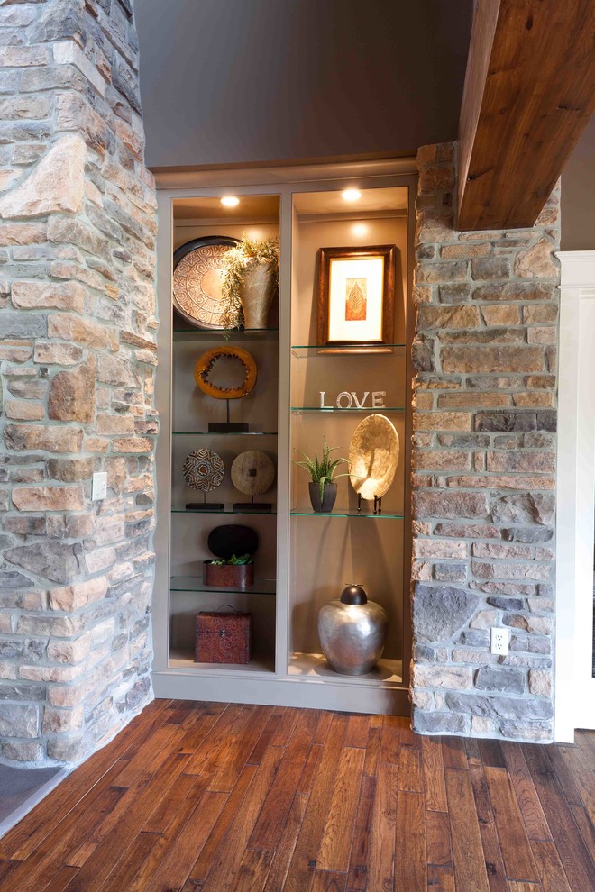 Exempel på ett stort lantligt separat vardagsrum, med bruna väggar, heltäckningsmatta, en standard öppen spis, en spiselkrans i sten, en väggmonterad TV och beiget golv