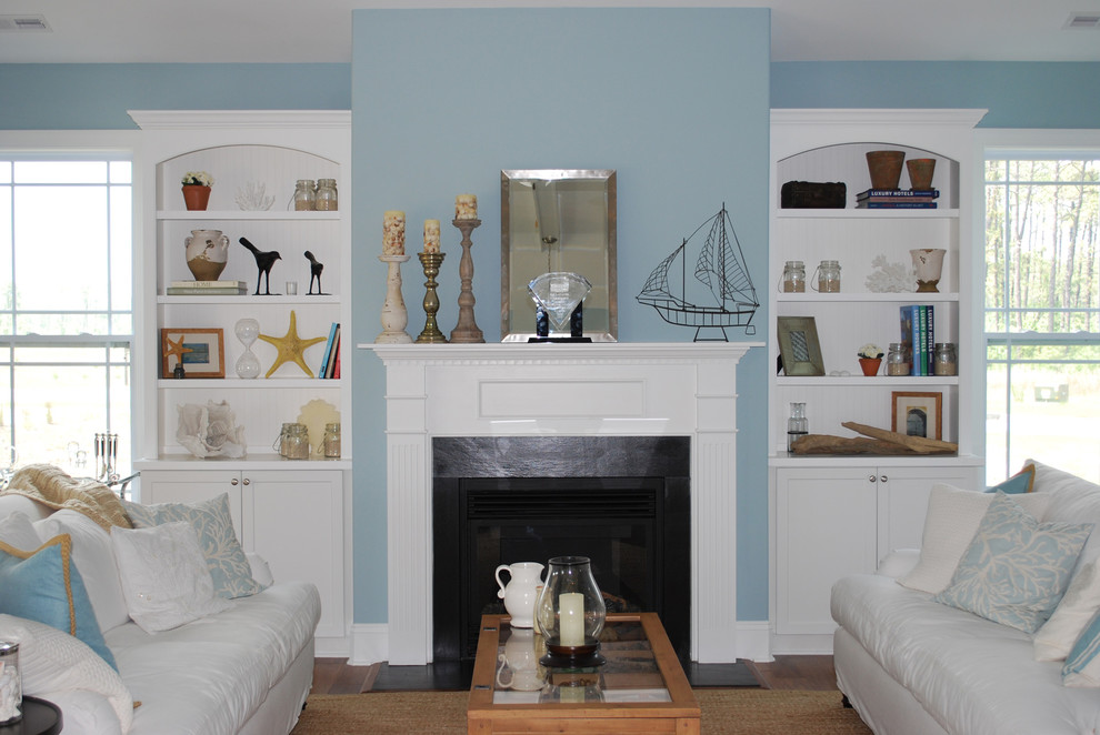 Imagen de salón abierto marinero de tamaño medio con paredes azules, suelo de madera en tonos medios, todas las chimeneas y marco de chimenea de piedra