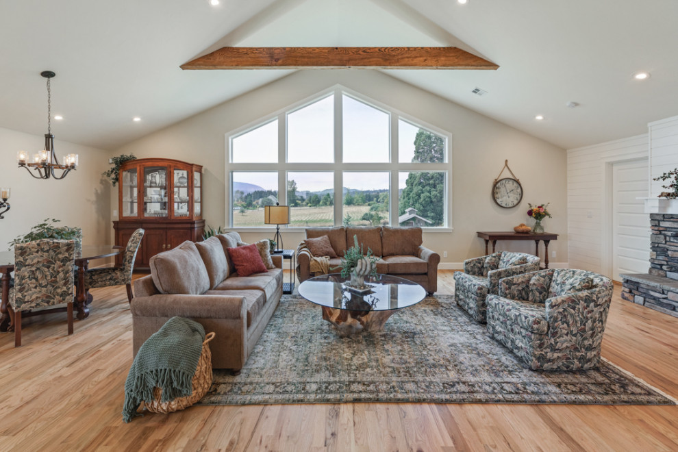 Large cottage formal and open concept medium tone wood floor, multicolored floor, vaulted ceiling and shiplap wall living room photo in Other with white walls, a standard fireplace, a stone fireplace and a wall-mounted tv