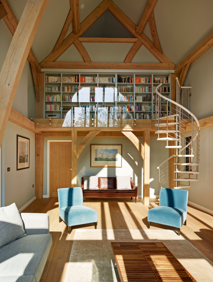 Inspiration pour un salon design de taille moyenne et ouvert avec une bibliothèque ou un coin lecture, un mur blanc, un sol en bois brun et un escalier.