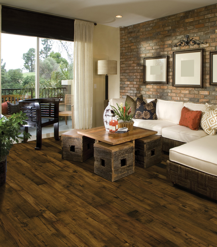Immagine di un soggiorno tropicale con pavimento in legno massello medio