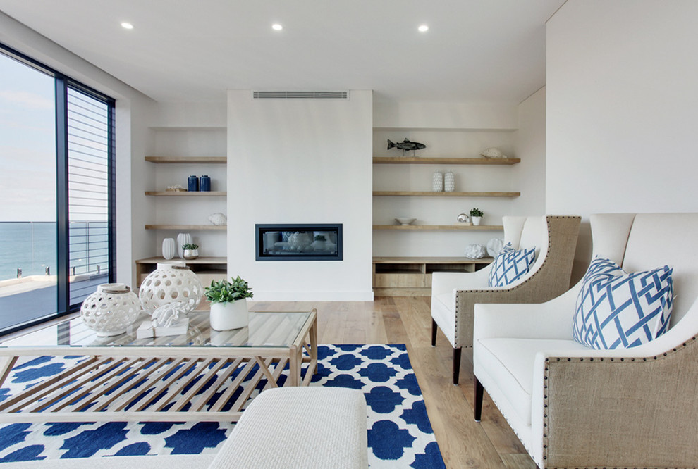 Свежая идея для дизайна: гостиная комната в морском стиле с белыми стенами, светлым паркетным полом и горизонтальным камином без телевизора - отличное фото интерьера