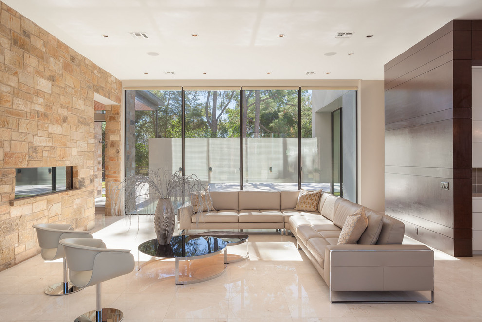 На фото: огромная гостиная комната в современном стиле с горизонтальным камином, фасадом камина из камня и белым полом с
