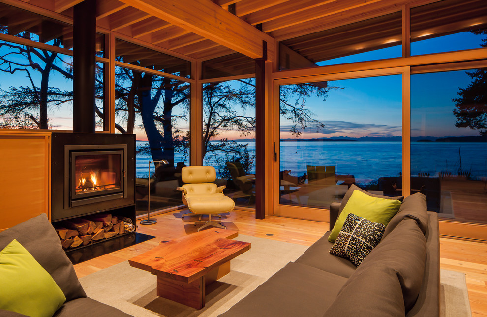 Offene Moderne Bibliothek mit braunem Holzboden, Kaminumrandung aus Metall, Kamin und verstecktem TV in Seattle