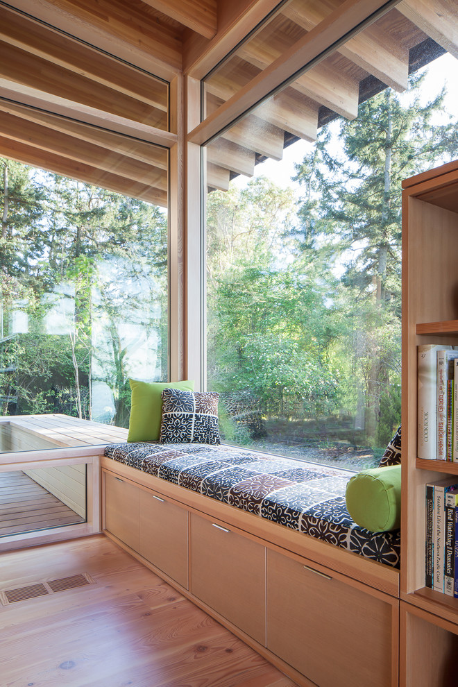 Ejemplo de biblioteca en casa contemporánea con suelo de madera en tonos medios
