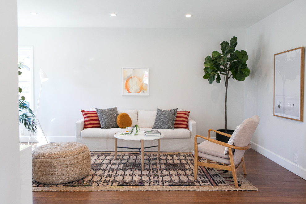 Immagine di un soggiorno minimal con pareti bianche, pavimento in legno massello medio e pavimento marrone