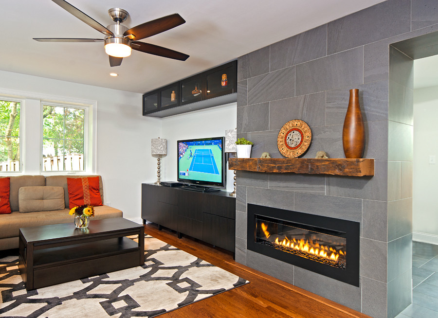 Aménagement d'un grand salon classique avec un mur blanc, un sol en bois brun, une cheminée ribbon et un téléviseur indépendant.