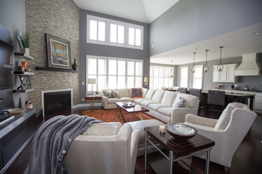 Идея дизайна: открытая гостиная комната в современном стиле с серыми стенами, стандартным камином, фасадом камина из плитки и ковром на полу