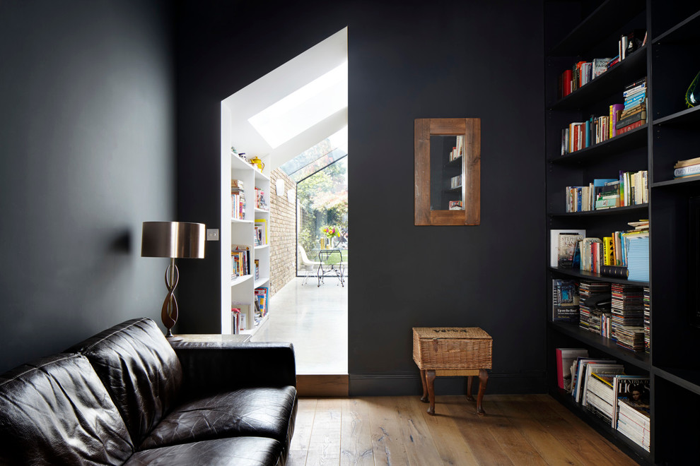 Exempel på ett litet modernt separat vardagsrum, med ett bibliotek, svarta väggar, mörkt trägolv och en inbyggd mediavägg