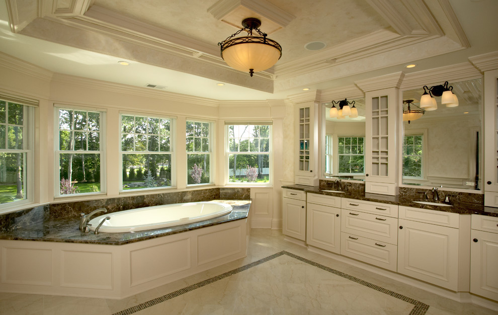 Esempio di una stanza da bagno stile rurale con ante con riquadro incassato, ante bianche, top in granito, vasca da incasso e pareti bianche